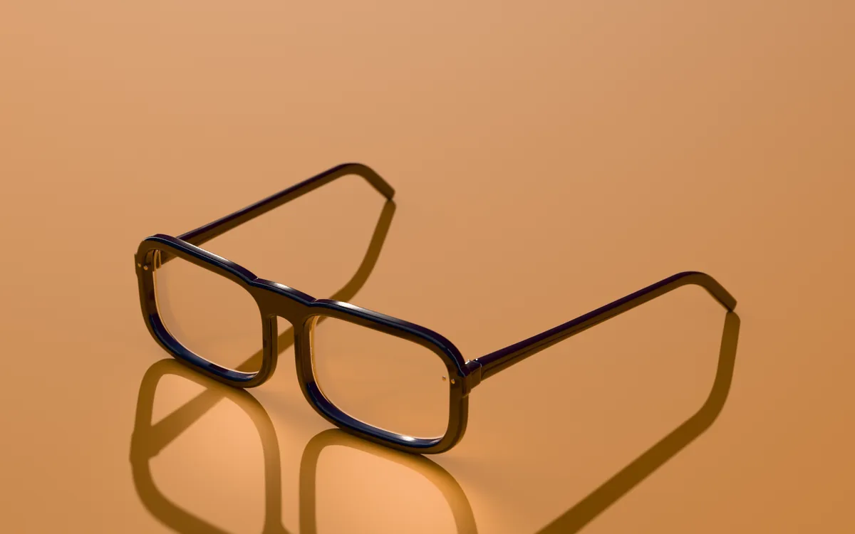 Bram rectangle glasses in Deep navy with clear lenses, in low sun on an apricot ground