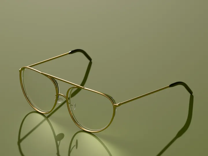 Sable aviator glasses in Brushed gold, in low sun on a warm ground
